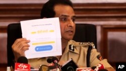 Mumbai police commissioner Hemant Nagrale displays a document as he addresses a press conference in Mumbai, India, Jan. 5, 2022. 