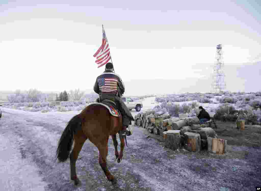 Cowboy Dwane Ehmer, pendukung kelompok yang menduduki Pusat Satwa Liar Malheur, mengendarai kudanya di dekat Burns, Oregon. Tiga sheriff bertemu dengan para pemimpin kelompok bersenjata tersebut untuk membujuk mereka menghakhiri pendudukan di pusat satwa liar tersebut setelah banyak penduduk setempat menyampaikan keinginan mereka.