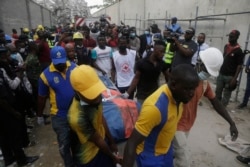 Rescue workers carry a body at the site of a collapsed 21-story apartment building under construction in Lagos, Nigeria, Nov. 1, 2021.