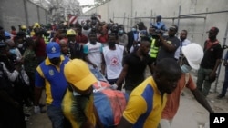 Des secouristes transportent un corps sur le site de l'effondrement d'un immeuble de 21 étages en construction à Lagos, au Nigeria, le 1er novembre 2021. 