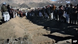 Villagers stand in front of the graves of people killed during an explosion in Sayedabad, Wardak southwest of Kabul, Afghanistan, Jan. 13, 2013. 