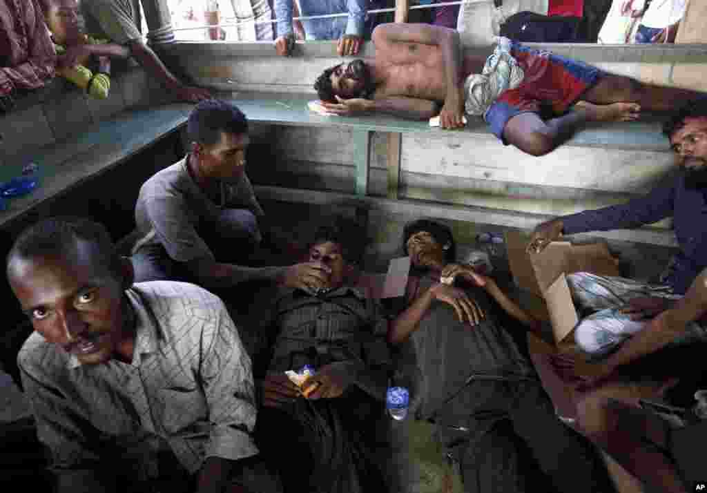 Rescued migrants rest as they are given food and drink upon arrival in Simpang Tiga, Aceh province, Indonesia, May 20, 2015.