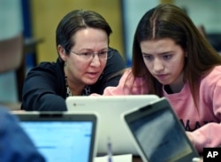 Jennifer Rocca, left, a teacher librarian at Brookfield, Conn., High School, works with Ariana Mamudi, 14, a freshman in her Digital Student class, Dec. 20, 2017. The required class teaches media literacy skills and has the students scrutinize sources for their online information.