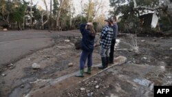 Des résidents observent la boue, les débris et la destruction causés par une coulée de boue massive à Montecito, en Californie, le 10 janvier 2018.
