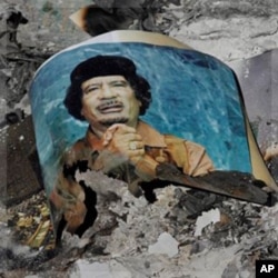 Picture of Libya's ousted leader Moammar Gadhafi is seen in the ashes in downtown Sirte, Libya, Wednesday, Oct. 12, 2011. (AP Photo/Bela Szandelszky)