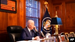 Nesta imagem fornecida pela Casa Branca, o Presidente Joe Biden conversa ao telefone com o presidente russo Vladimir Putin a partir da sua residência privada em Wilmington, Delaware (30 Dezembro 2021) (Adam Schultz/The White House via AP)
