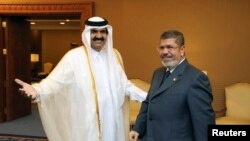 Qatar's Emir Sheikh Hamad bin Khalifa al-Thani (L) greets Egypt's President Mohamed Mursi during the Arab League summit in Doha, March 26, 2013. 