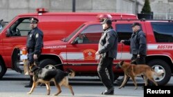 Polisi dan anjing pelacak menyisir wilayah terjadinya ledakan dekat garis finish lomba marathon Boston (15/4).