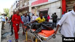 Somali emergency services evacuate a body from a car bombing at a shopping mall in Mogadishu, Somalia, Feb. 4, 2019. Al-Shabab claimed responsibility for the attack.