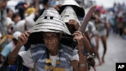 Wearing their traditional warrior helmets and jewelry, Tao aboriginal elders arrive at a traditional fishing boat launching ceremony in a village on Orchid Island, Taiwan.