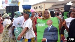 Une Guinéenne montre une affiche du parti de l'opposition UDFG, le 2 février 2018 à Conakry.