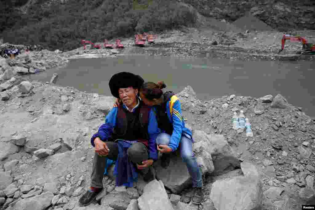 Relatives of victims react at the site of a landslide in the village of Xinmo, Mao County, Sichuan Province, China.