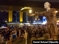 A wood art sculpture titled "Umbrella Man" sits amidst the Hong Kong Occupy Central protest area, Oct. 5, 2014.