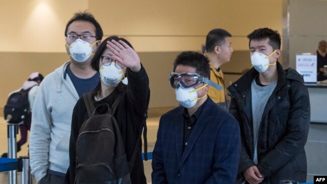 戴着口罩的中国旅客在洛杉矶国际机场等待飞往上海的临时机位。(2020年2月2日资料照)