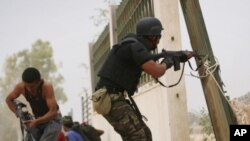 Libyan revolutionary fighters fire toward pro-Gadhafi forces in Sirte, Libya, Saturday, Oct. 8, 2011