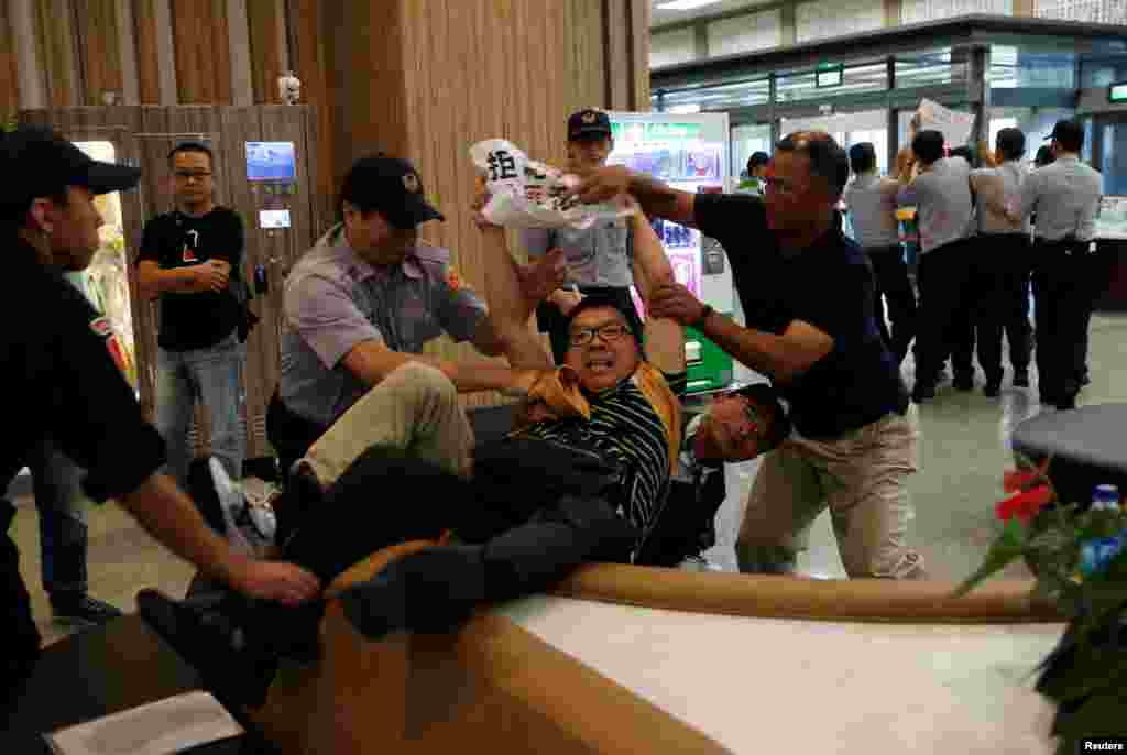 Anti-China demonstrators are stopped by police as Sha Hailin, a member of Shanghai&rsquo;s Communist Party standing committee, arrives for a forum at Songshan Airport in Taipei, Taiwan.