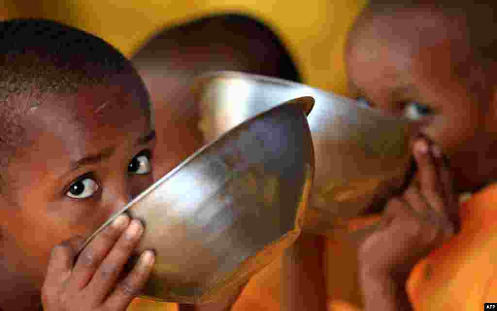 August 2: Somali refugee boys eat porridge during break time at the Liban integrated academy at the Ifo refugee camp in Dadaab, near the Kenya-Somalia border. REUTERS/Thomas Mukoya