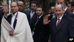 Tunisia's new president Moncef Marzouki, left, is accompanied by Libyan Transitional National Council chairman Mustafa Abdul-Jalil after his arrival in Tripoli, Libya, Monday, Jan. 2, 2012.