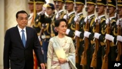 China's Premier Li Keqiang (L) and Myanmar State Counselor and Foreign Minister Aung San Suu Kyi review an honor guard during a welcome ceremony at the Great Hall of the People in Beijing, Aug. 18, 2016.