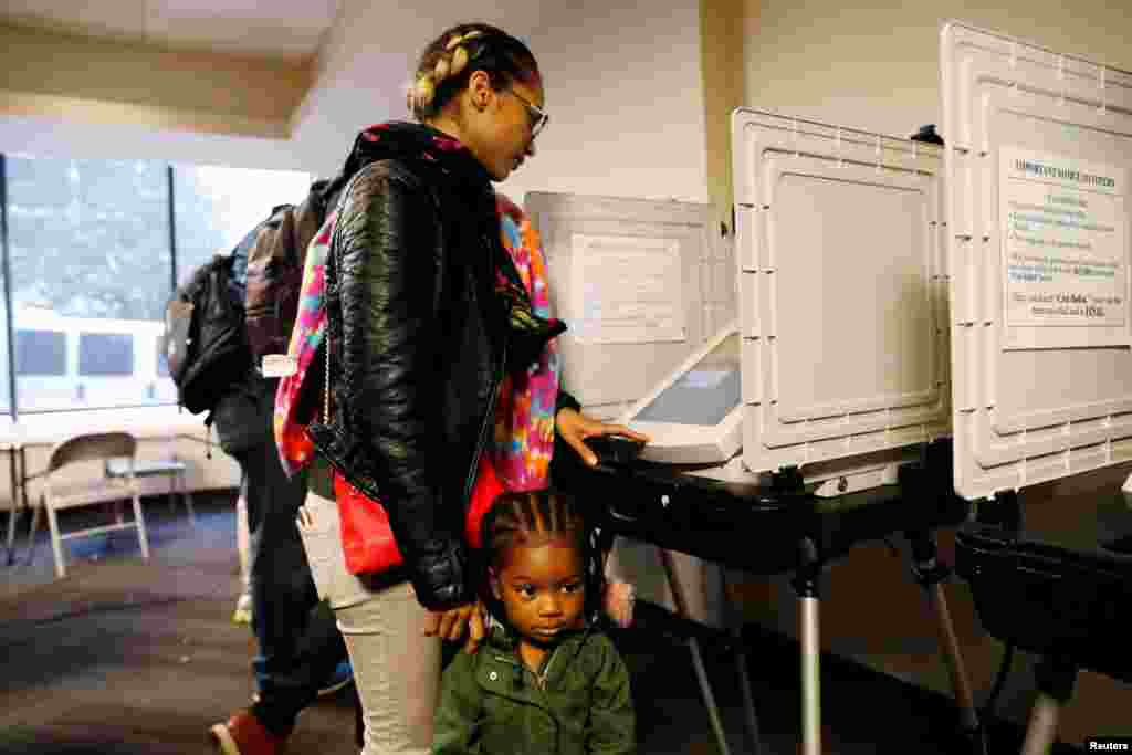 2-year-old Kadence Bethea waits for her mother Lindsey Adams to finish casting her vote in the U.S. midterm election after they waited in line for more than an hour and a half at a Fulton County polling place in Atlanta, Georgia, Nov. 6, 2018. 