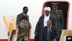 Sudan's leader Omar al-Bashi, center, leaves his aircraft as he arrives at Beijing International Airport, June 28, 2011.