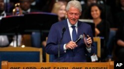 Mantan Presiden AS Bill Clinton tersenyum saat memperdengarkan rekaman lagu Aretha Franklin dari ponselnya pada upacara pemakaman Aretha Franklin di Greater Grace Temple, Detroit, Michigan (31/8).