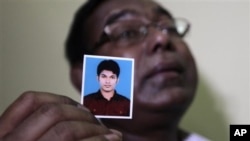 Quazi Ahsanullah displays photograph of his son Quazi Mohammad Rezwanul Ahsan Nafis, Dhaka, Bangladesh, Oct. 18, 2012.