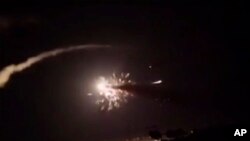 This frame grab from a video provided by the Syrian official news agency SANA shows missiles flying into the sky near Damascus, Syria, Dec. 25, 2018.