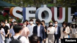 한국의 서울 시내 직장인들이 마스크를 쓴 채 횡단보도를 건너고 있다. 