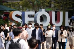 FILE - Commuters wearing masks to avoid contracting the coronavirus disease (COVID-19) walk on a zebra crossing in Seoul, South Korea, Sept. 24, 2021.