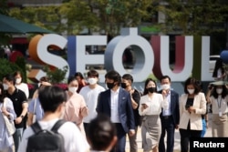 FILE - Commuters wearing masks to avoid contracting the coronavirus disease (COVID-19) walk on a zebra crossing in Seoul, South Korea, Sept. 24, 2021.