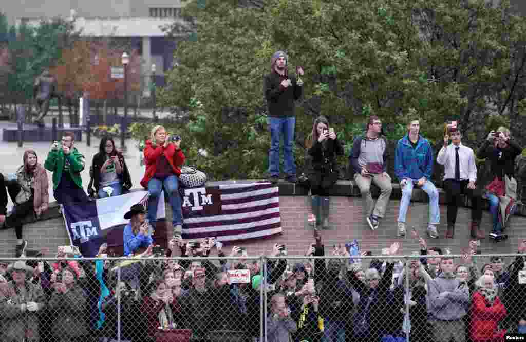 People pay their respects as the hearse carrying the casket of former President George H.W. Bush arrives on the Texas A&M campus, Dec. 6, 2018, in College Station, Texas.