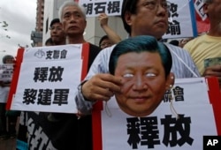 FILE - A protester holds mask of Chinese President Xi Jinping during demonstration for Chinese journalist Gao Yu, Hong Kong publisher Yao Wentian, and Chinese lawyer Pu Zhiqiang, Chinese liaison office, Hong Kong, May 11, 2014.