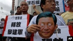 Protester holds mask of Chinese President Xi Jinping during demonstration for Chinese journalist Gao Yu, Hong Kong publisher Yao Wentian, and Chinese lawyer Pu Zhiqiang, Chinese liaison office, Hong Kong, May 11, 2014.