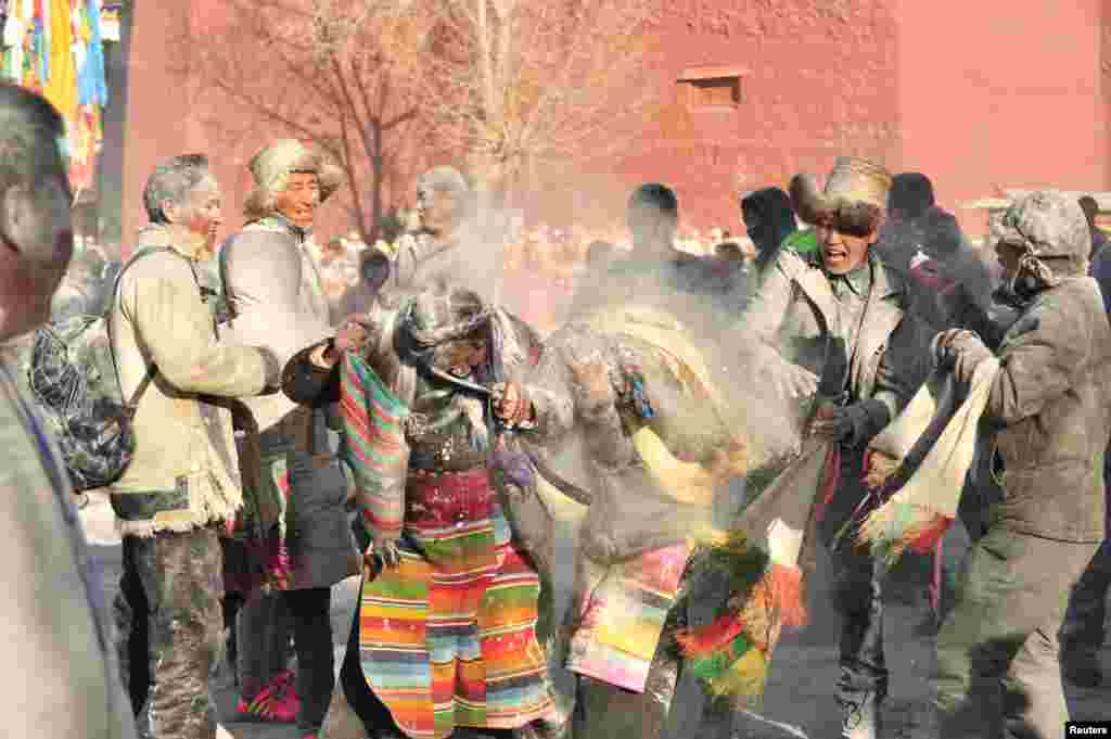 Tibetans throw &quot;zanba,&quot; traditional roasted flour, at each other during a zanba fight event to pray for a good harvest in Shigatse, Tibet Autonomous Region, China, Feb. 22, 2016.