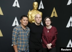 “The Look of Silence” documentary subject Adi Rukun and filmmakers Joshua Oppenheimer, center, and Signe Byrge Sorensen pose at a reception in Beverly Hills, Calif., Feb. 24, 2016. The film is an Academy Awards contender.