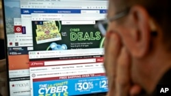 A journalist looks at a computer screen with webpages arranged to show Cyber Monday deals by various online retailers, Nov. 26, 2018, in New York.