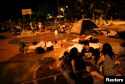 FILE - People prepare to sleep on the floor of a sports center, where a community of homeless Venezuelan migrants stays, in Cucuta, Colombia, Jan. 24, 2018.