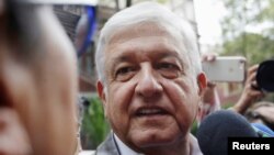 FILE - Mexican President-elect Andres Manuel Lopez Obrador talks to a journalist as he arrives for a meeting with his new cabinet in Mexico City, July 7, 2018.