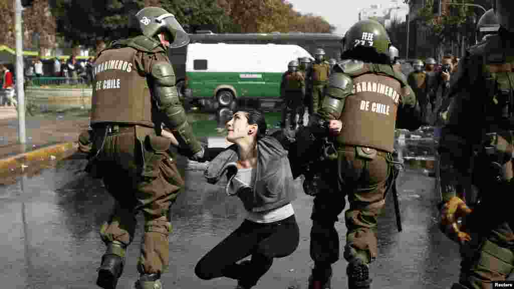 A demonstrator is detained during May Day rallies in Santiago, Chile May 1, 2013.