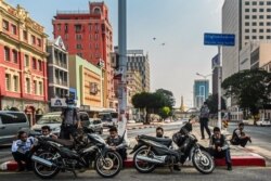 Pasukan keamanan duduk di sepanjang pembatas jalan di pusat kota Yangon, 10 Maret 2021, ketika mereka terus menindak keras aksi unjuk rasa menentang kudeta militer. (Foto: STR / AFP)