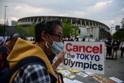 FILE - People take part in a protest against the hosting of the 2020 Tokyo Olympic Games outside the Olympic museum in Tokyo on May 9, 2021. (AFP)