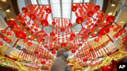 A woman walks under Chinese Lunar New Year decoration at a shopping mall in Kuala Lumpur, Malaysia.