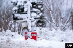 Snow covers a placard for U.S. Republican presidential candidate Florida Governor Ron DeSantis in Davenport, Iowa, on Jan. 11, 2024, as record-breaking cold continues to complicate the Iowa caucuses with snowy weather canceling many events.