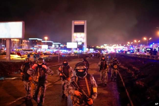 Sejumlah petugas Garda Nasional Rusia mengamankan area Crocus City Hall yang menjadi tempat penembakan massal di pinggiran sebelah barat Moskow, Rusia, Sabtu, 23 Maret 2024. (Foto: Alexander Avilov/Moscow News Agency via AP)