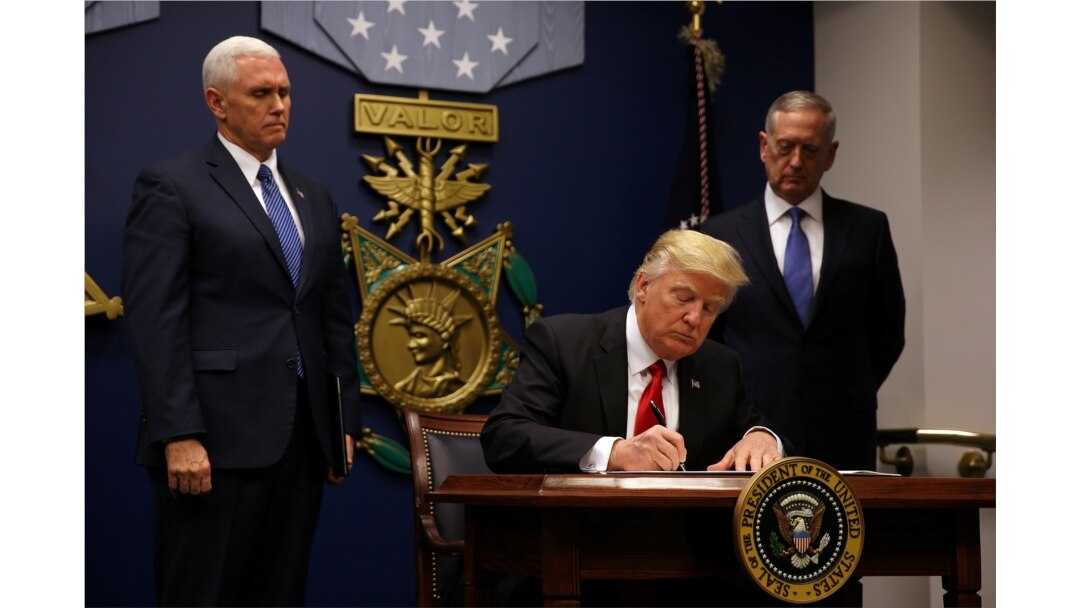 FILE - U.S. President Donald Trump signs an executive order he said would impose tighter vetting to prevent foreign terrorists from entering the United States, at the Pentagon, in Arlington, Virginia, Jan. 27, 2017.