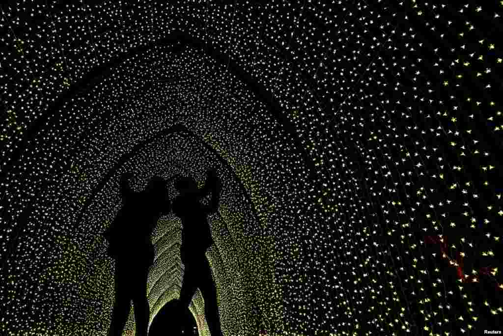 Visitors take photos of a light installation as the illuminated trail opens at Kew Gardens in London, Nov. 19, 2019.