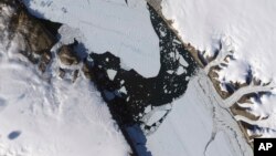 This Aug. 16, 2010, image provided by NASA Earth Observatory shows a piece of the Petermann Glacier that cracked in Greenland.