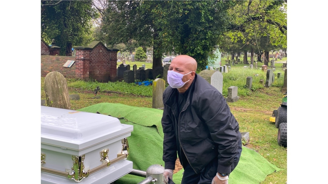 Yilma Asfaw grieving at the funeral of his wife, Wegene Debele of Takoma Park, Maryland. They have been together for 25 years. She was eight months pregnant when she contracted the coronavirus.