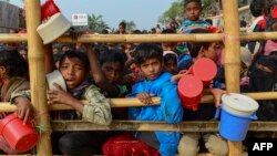 Rohingya refugees wait for food aid at Thankhali refugee camp in Bangladesh's Ukhia district on January 12, 2018.